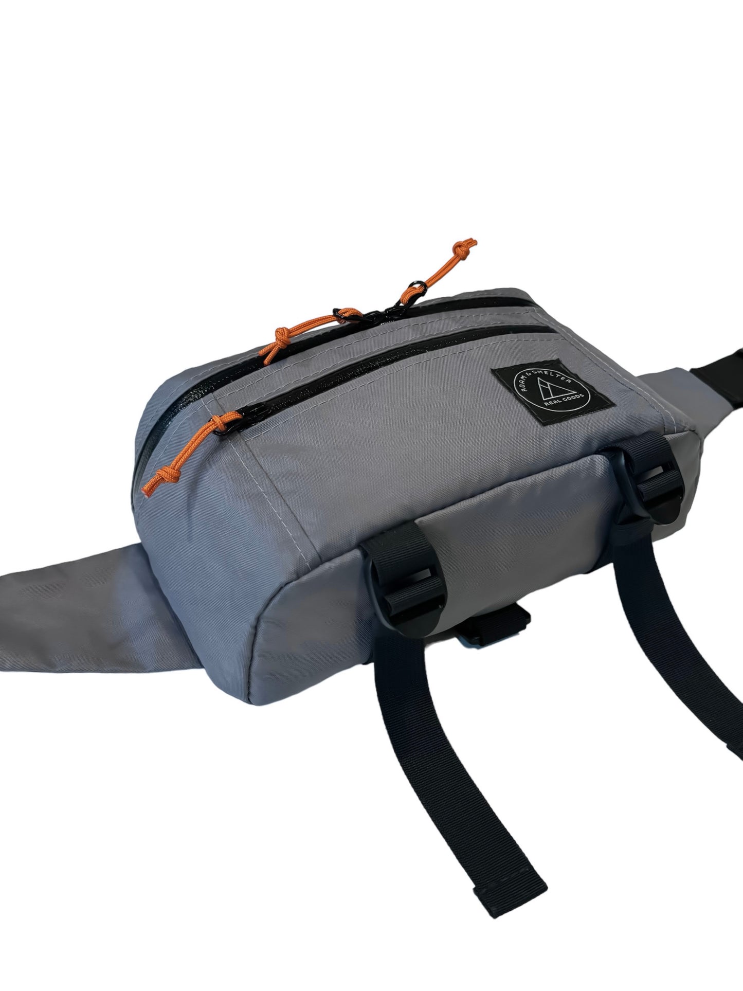 A gray hip pack with dual zipper main compartment, external front pocket, and an adjustable strap. It features orange zipper pulls and additional straps for jacket storage. Handmade in Portland Oregon USA.