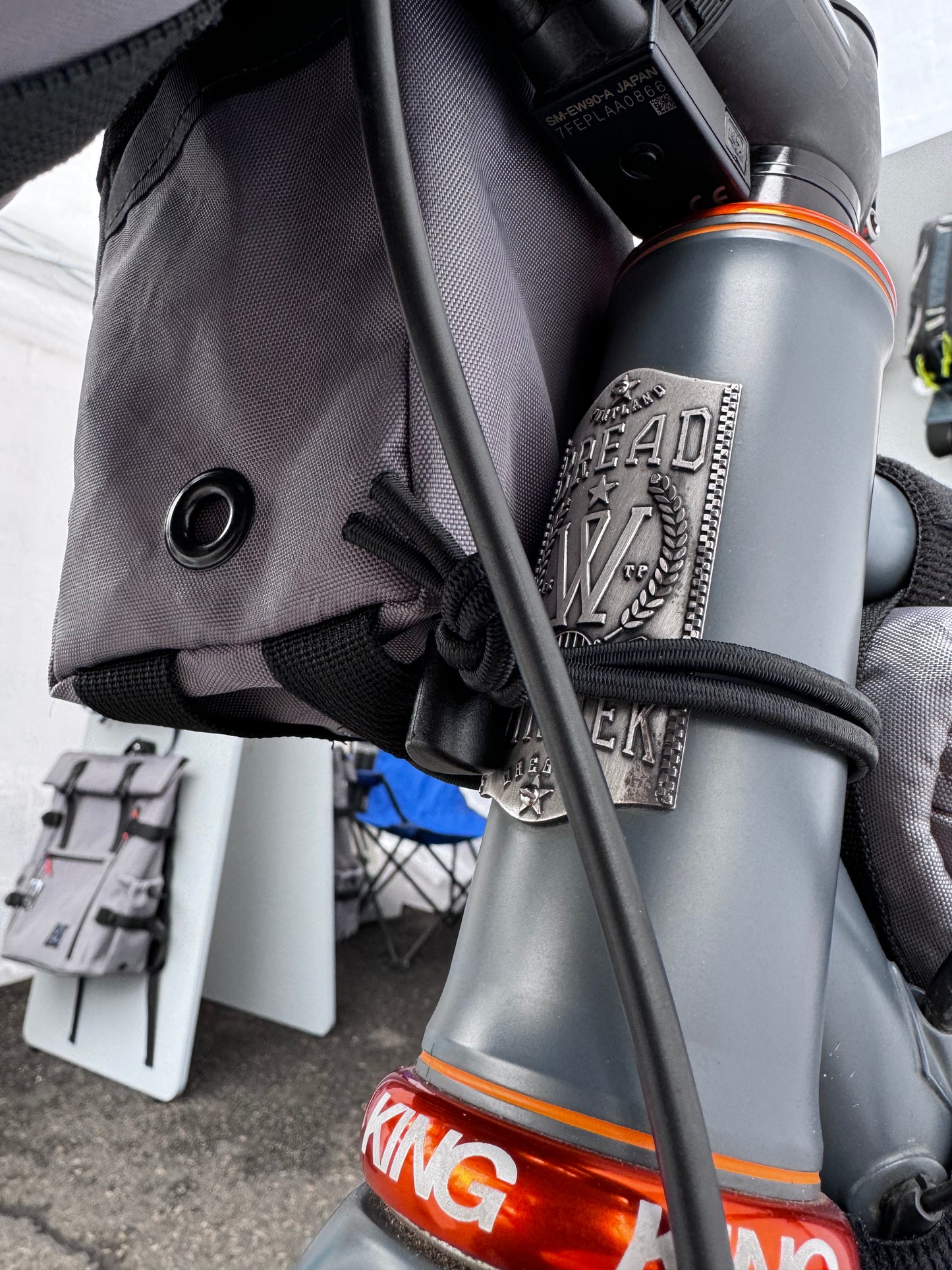 A gray stem bag attached to a bicycle's stem and handlebar, featuring a drawstring closure and made of Ecopak 400 material.  Two external pockets.  Handmade in Portland Oregon USA.
